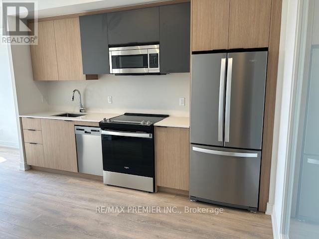 A kitchen with a stainless steel refrigerator and dishwasher.