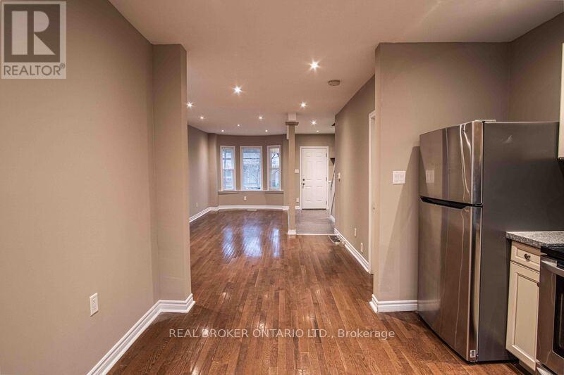 A spacious kitchen with wood flooring and stainless steel appliances.