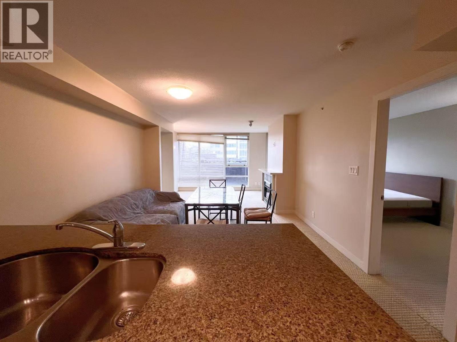 A bedroom with a bed, a chair, and a dining table.