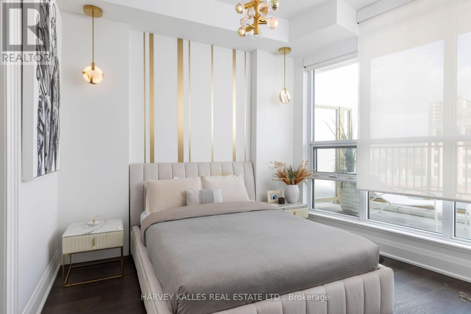 A bedroom with a large bed and a chandelier.