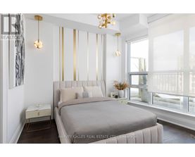 A bedroom with a large bed and a chandelier.
