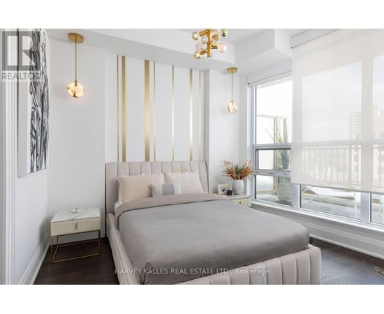 A bedroom with a large bed and a chandelier.