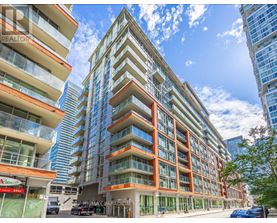 A tall residential building with balconies and a glass facade.