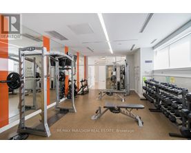 A gym with orange walls and a variety of equipment.