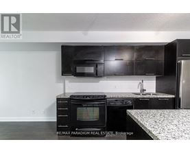 A kitchen with black cabinets and a white countertop.