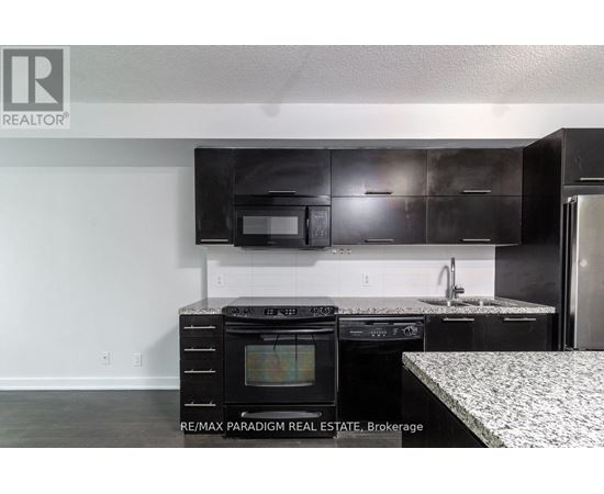 A kitchen with black cabinets and a white countertop.