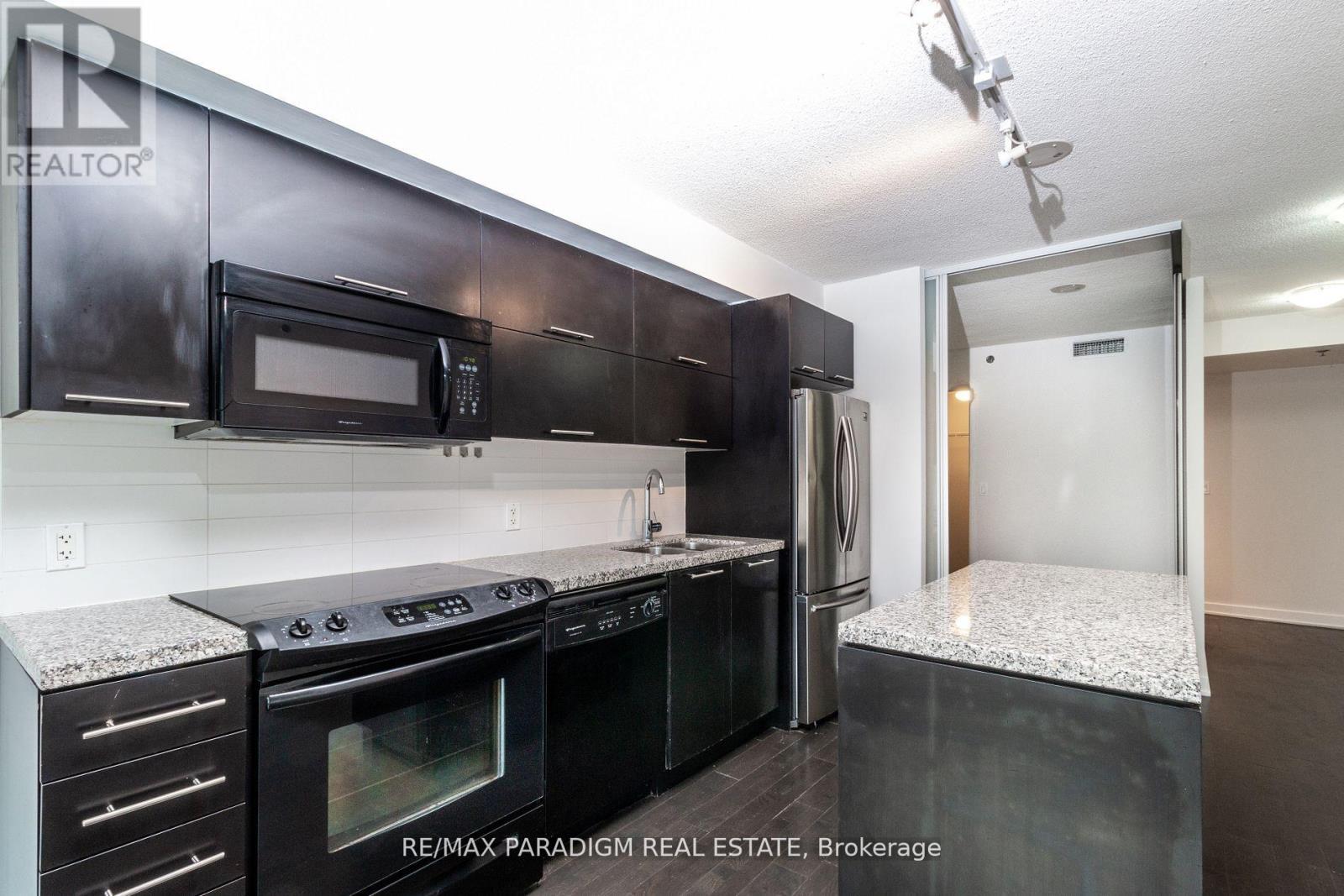 A kitchen with black cabinets and appliances is for sale.