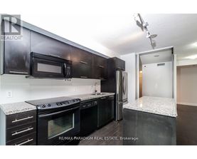 A kitchen with black cabinets and appliances is for sale.