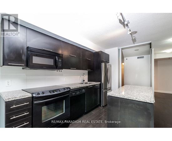 A kitchen with black cabinets and appliances is for sale.
