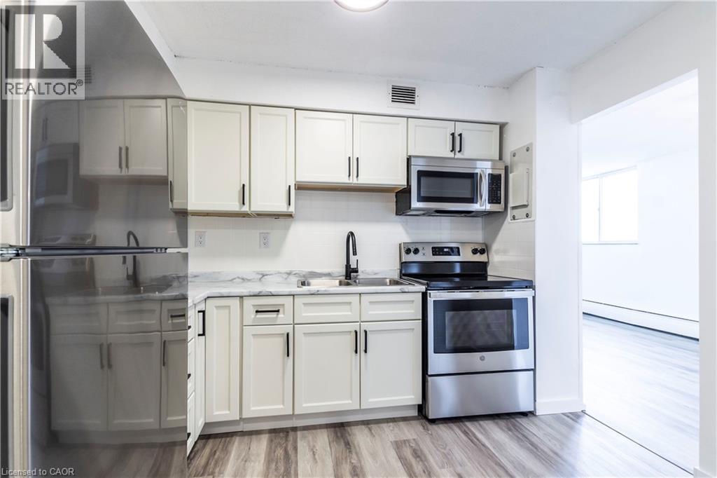 A kitchen with white cabinets and stainless steel appliances.