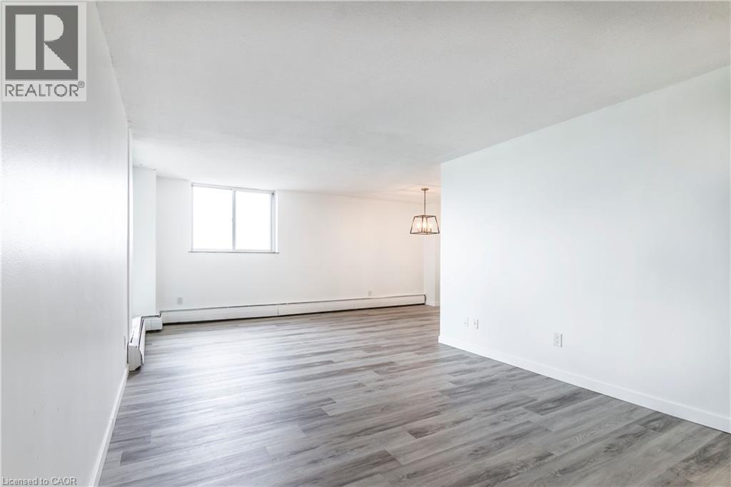 A spacious room with wooden flooring and a window.