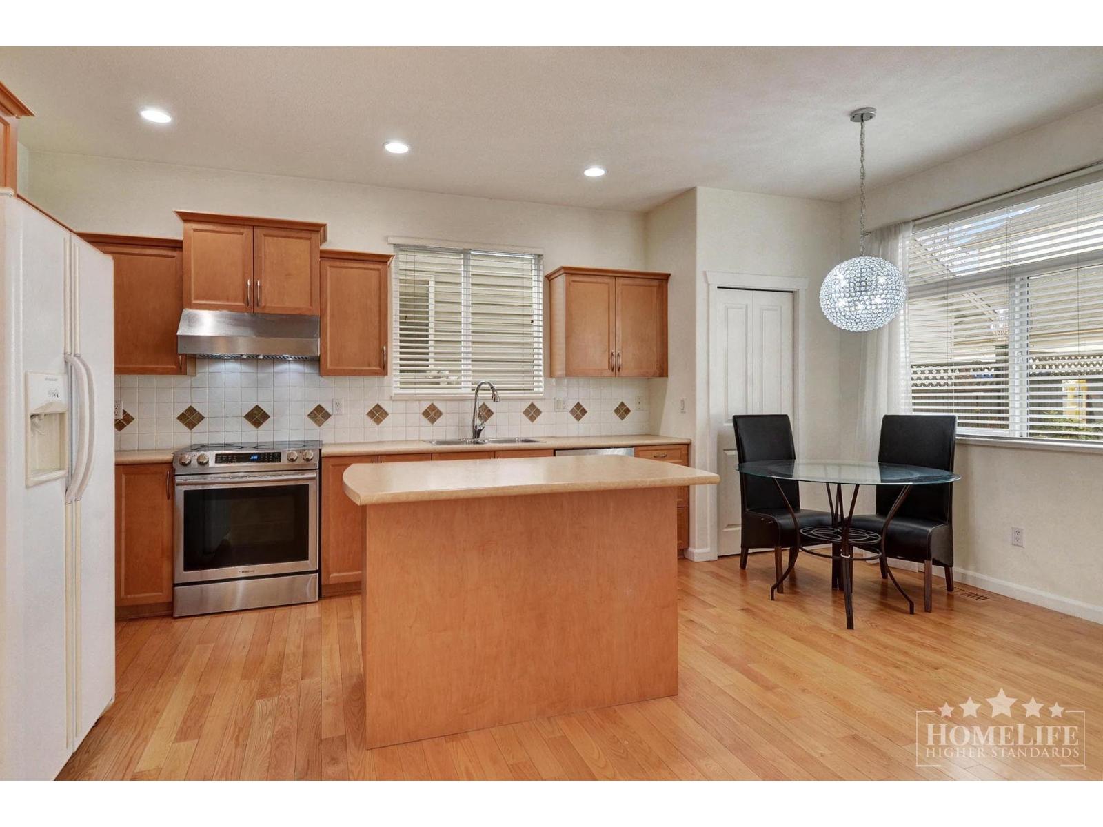 A kitchen with wooden cabinets and a white refrigerator.