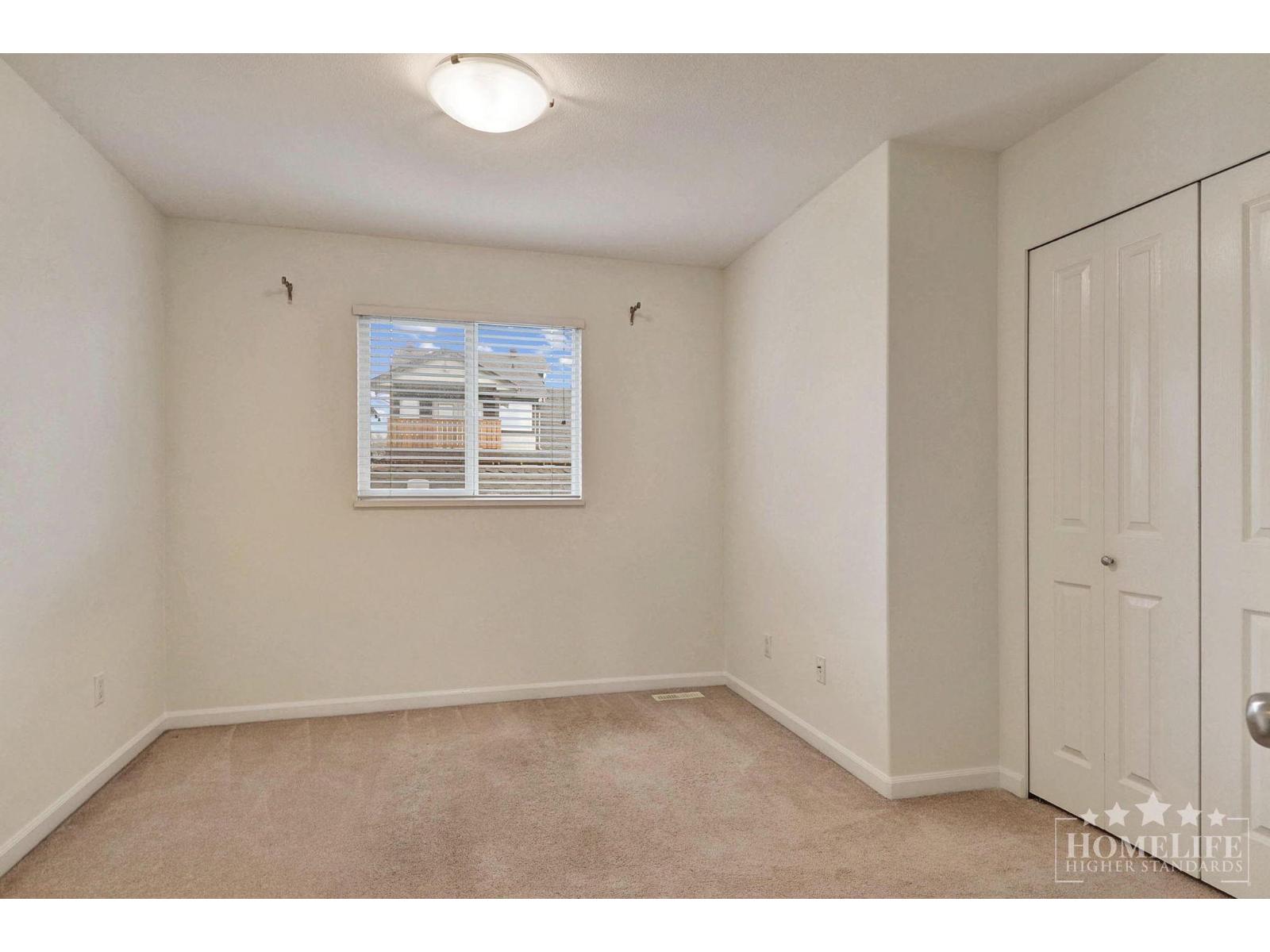 A bedroom with a window and a door.