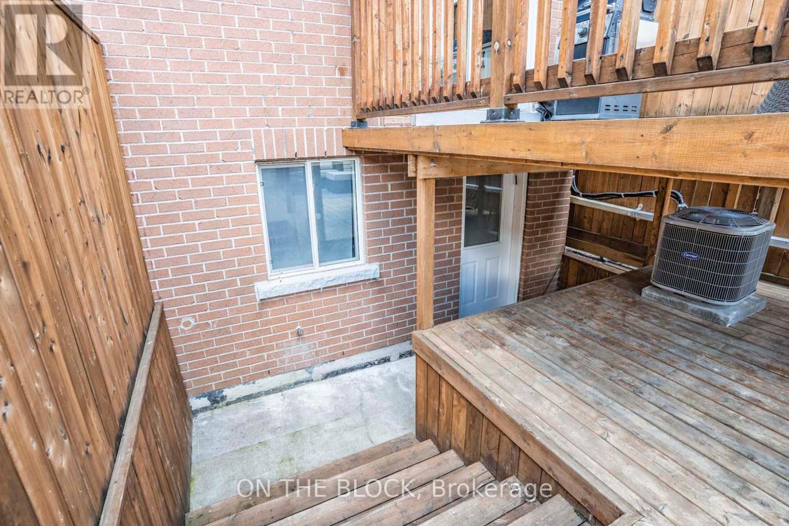 A wooden deck with a brick building in the background.