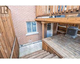 A wooden deck with a brick building in the background.