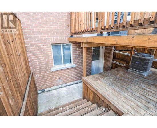 A wooden deck with a brick building in the background.