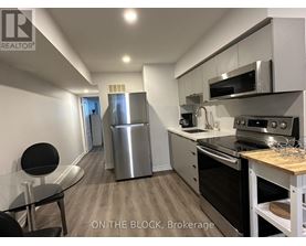 A modern kitchen with stainless steel appliances and a dining table.