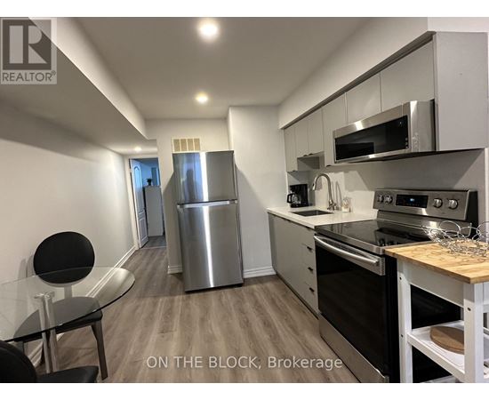 A modern kitchen with stainless steel appliances and a dining table.