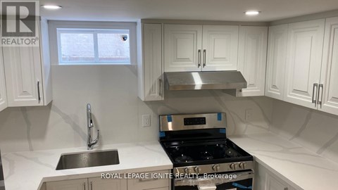 A kitchen with white cabinets and a stainless steel stove top.
