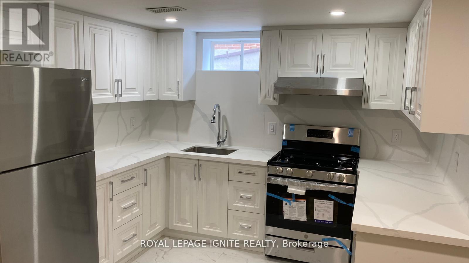 A kitchen with white cabinets and stainless steel appliances.