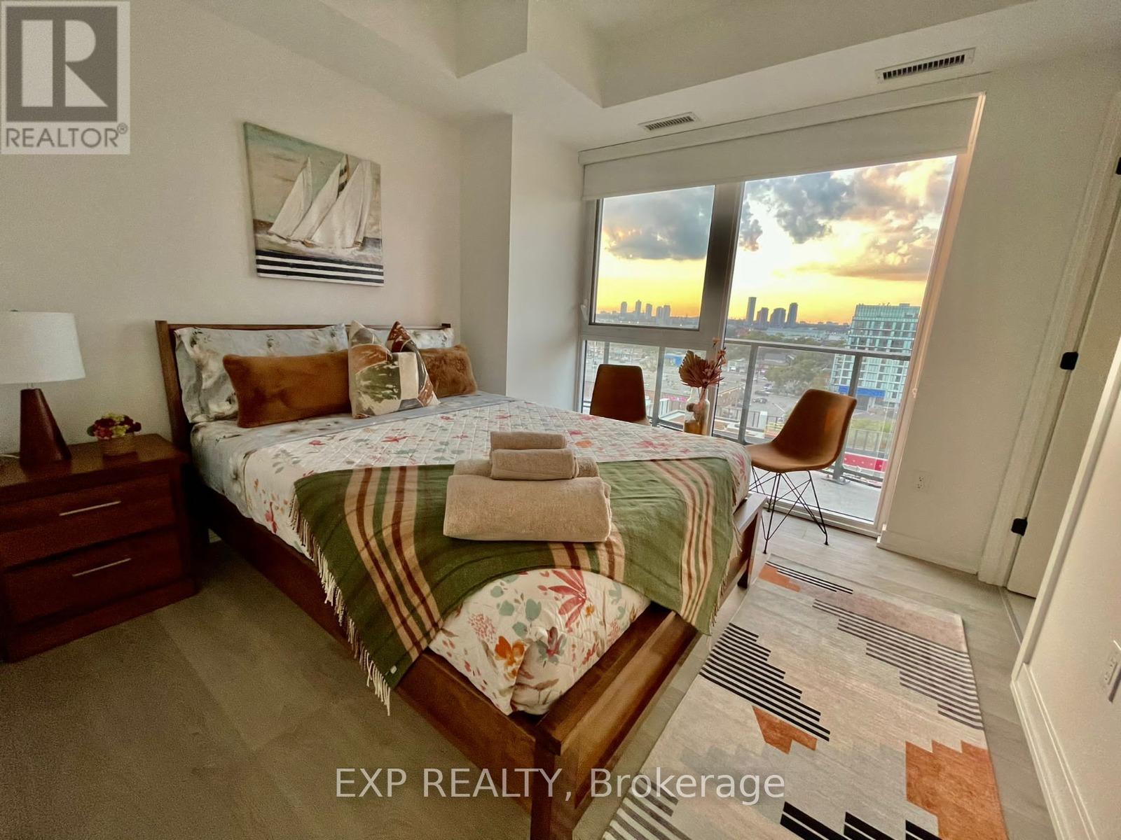 A bedroom with a large bed and a view of the city.