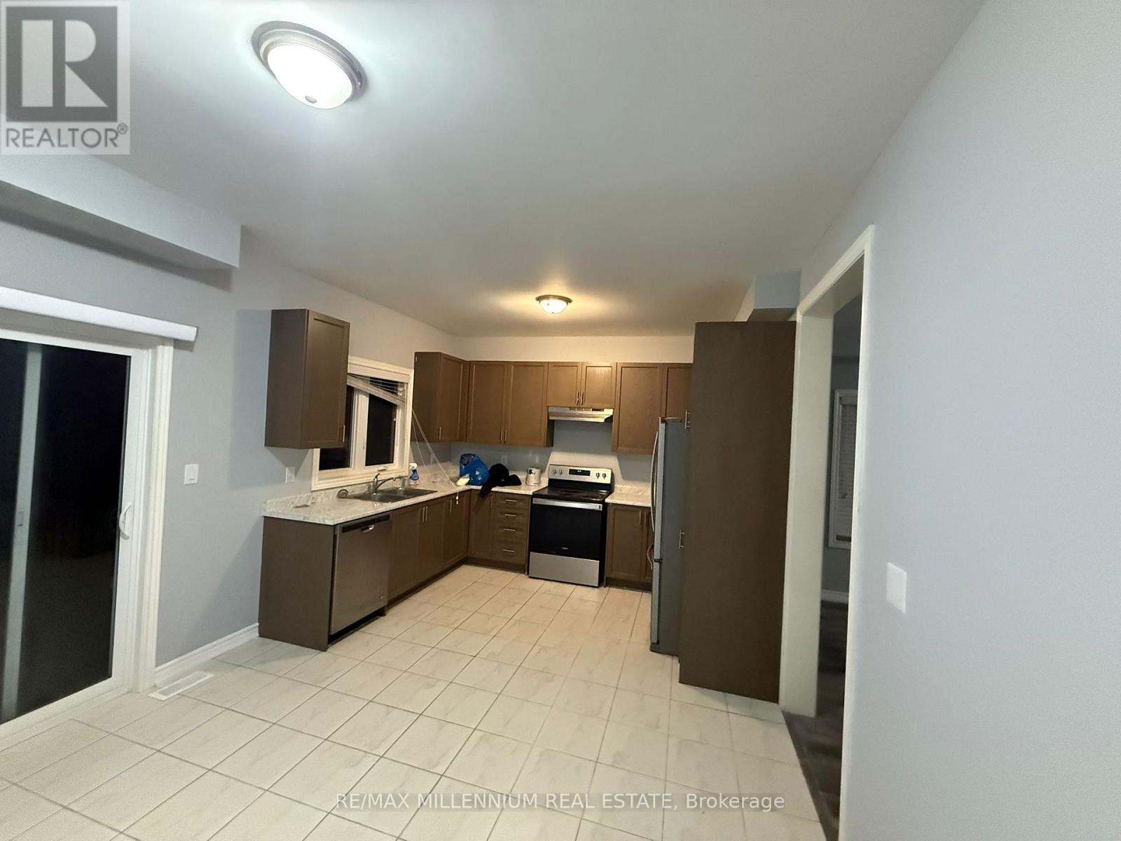 A kitchen with white tiled floors and brown cabinets.