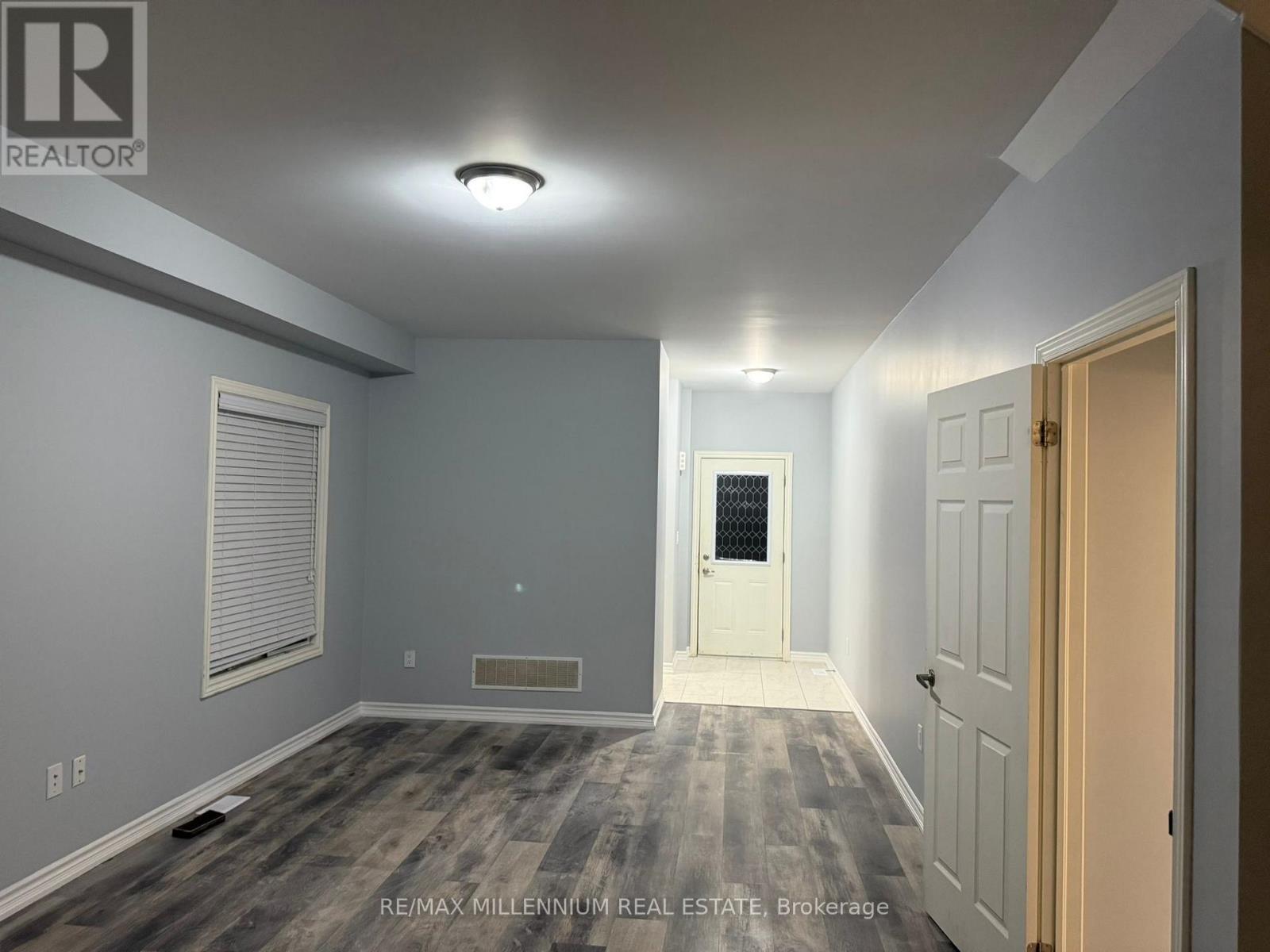 A room with a door and a window with blinds.