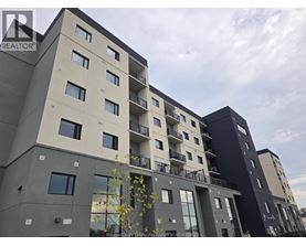 A modern apartment building with balconies and multiple windows.
