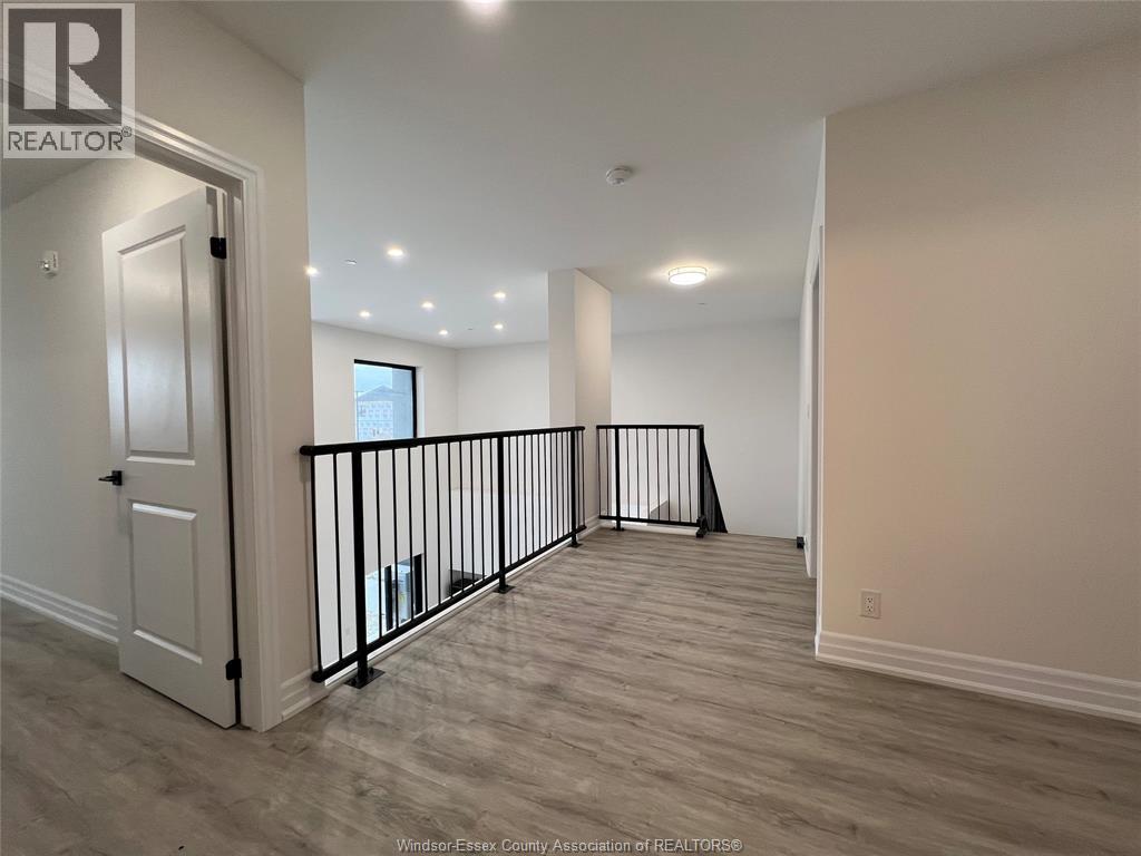 A spacious room with a balcony and hardwood flooring.