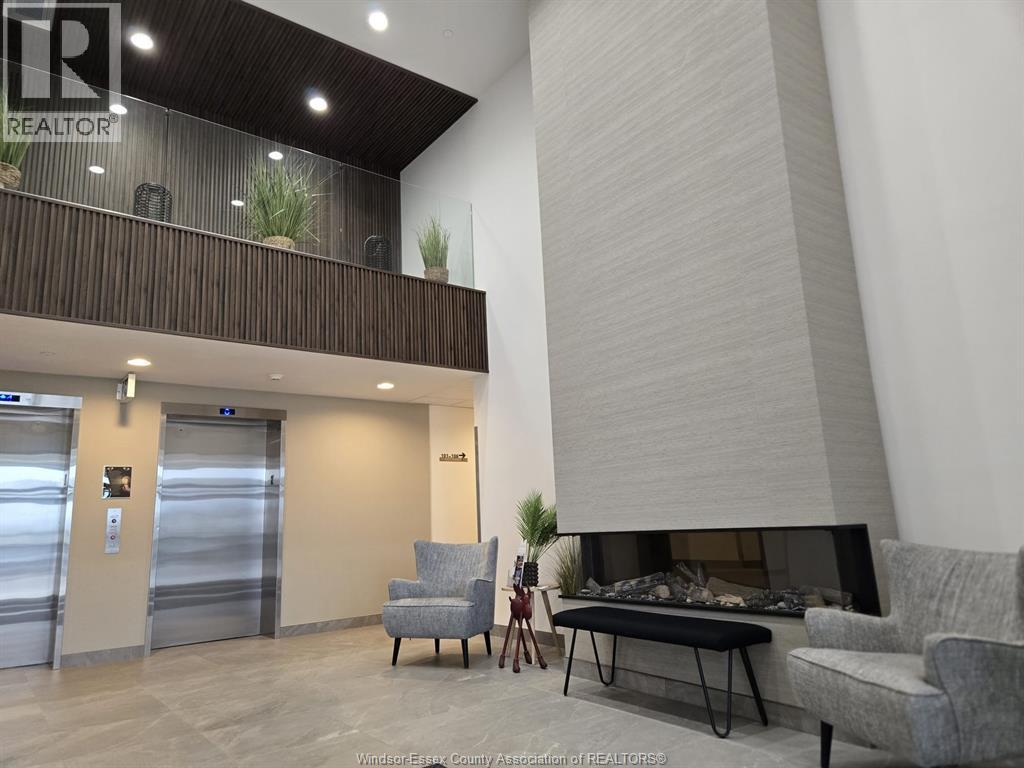 A living room with a grey couch and a fireplace.