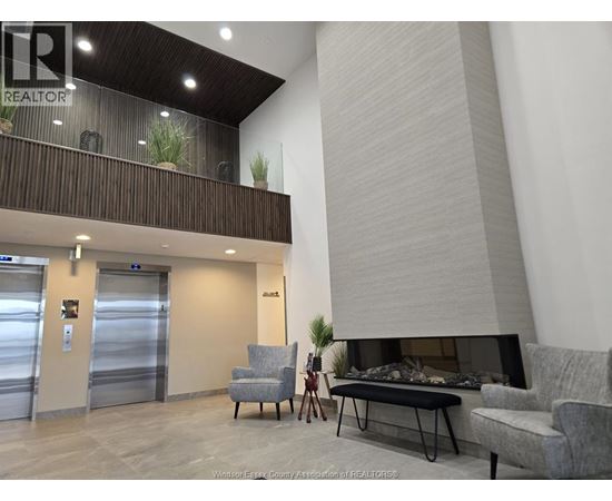 A living room with a grey couch and a fireplace.