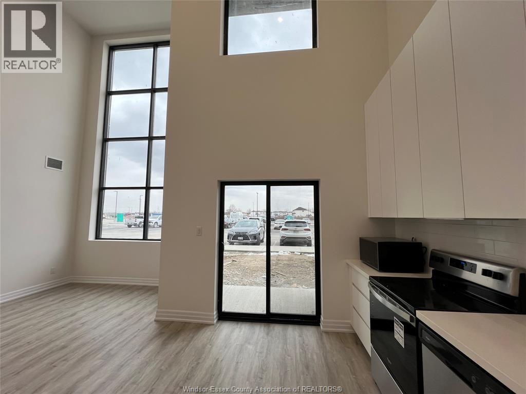 A kitchen with white cabinets and a black stove top oven.