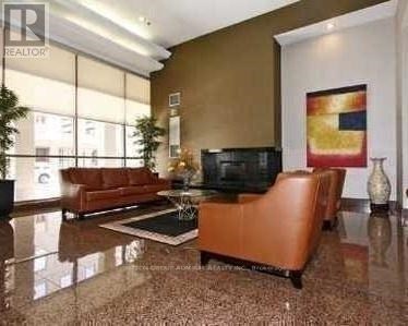 A living room with a brown leather sofa and a television set.