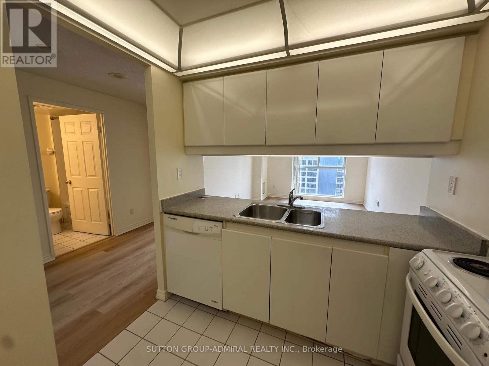 A kitchen with white cabinets and a stove top oven.