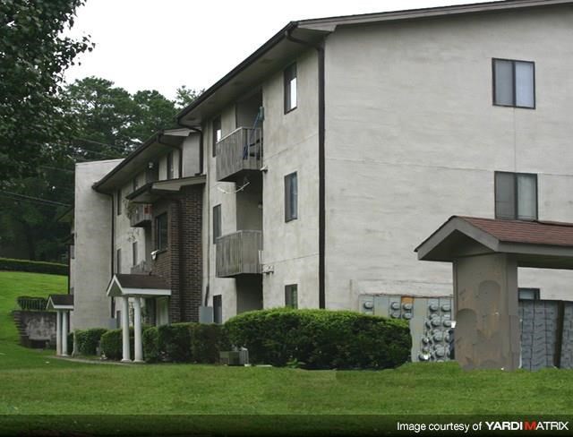 a white apartment building with a yard and grass