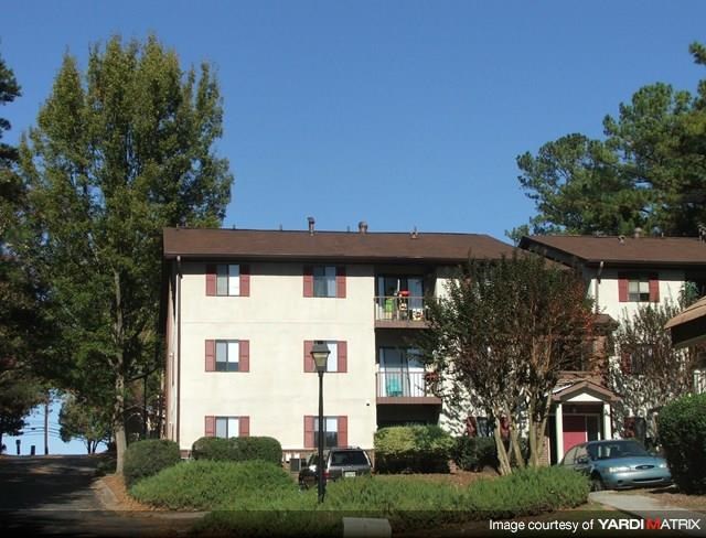 an apartment building with cars parked in front of it