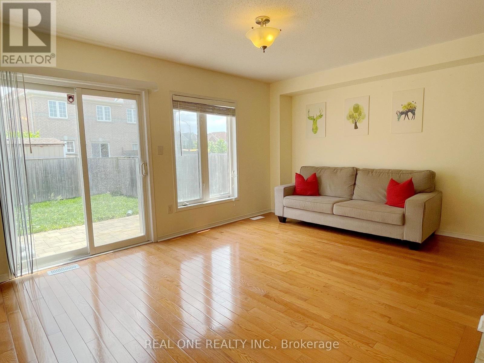 A living room with a couch, sliding glass doors, and pictures on the wall.