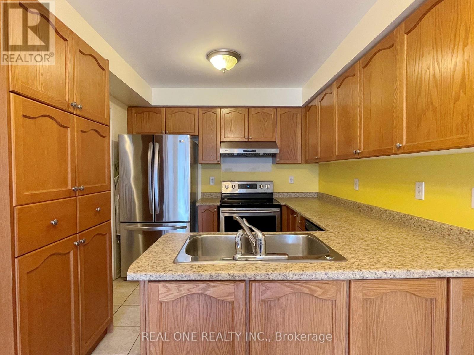 A kitchen with wooden cabinets and a granite countertop.
