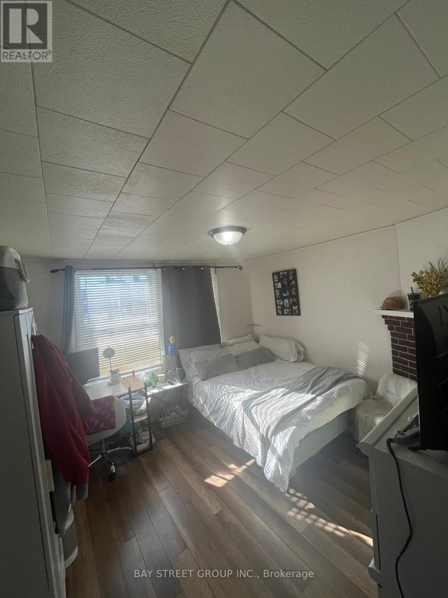 A bedroom with a bed, chair, and window.