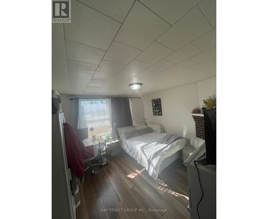 A bedroom with a bed, chair, and window.