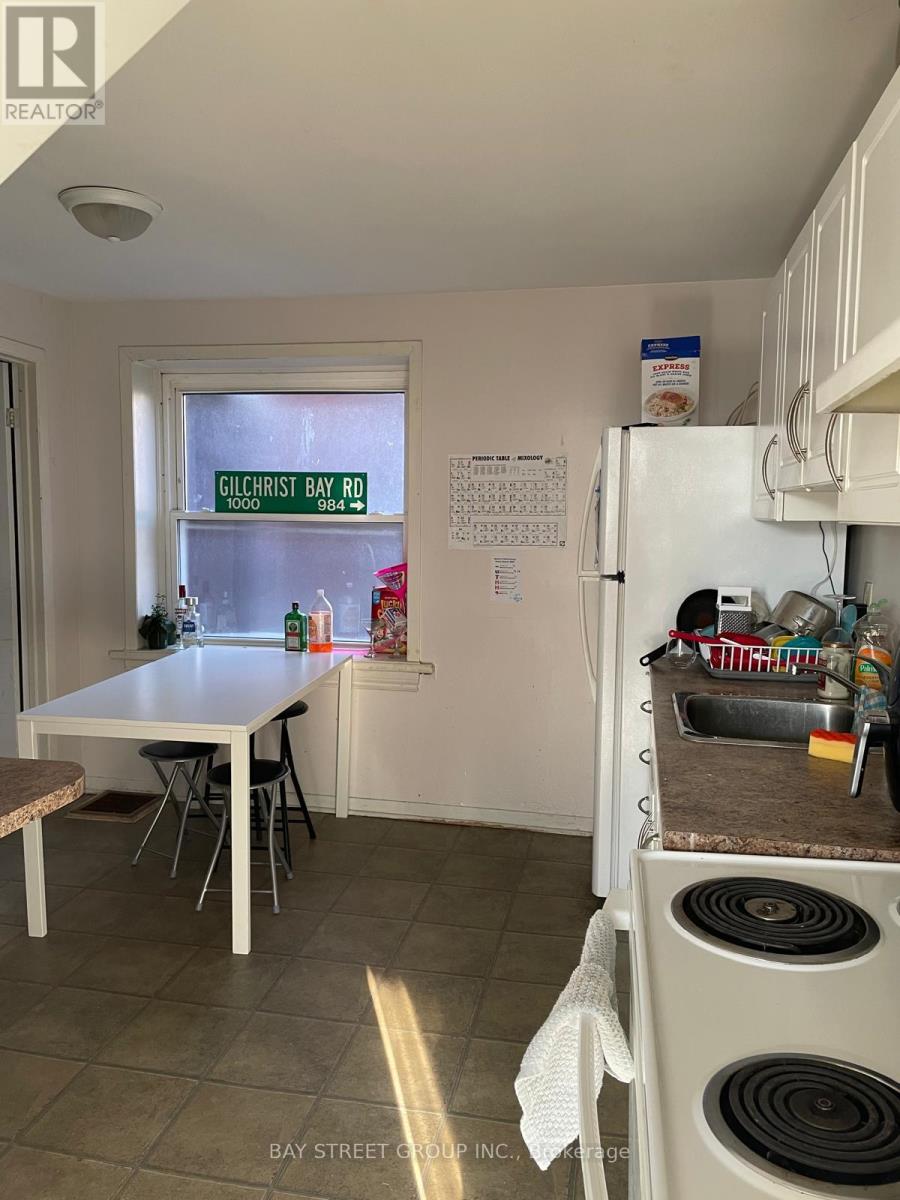 A kitchen with a table and chairs and a window with a sign on it.