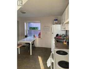 A kitchen with a table and chairs and a window with a sign on it.