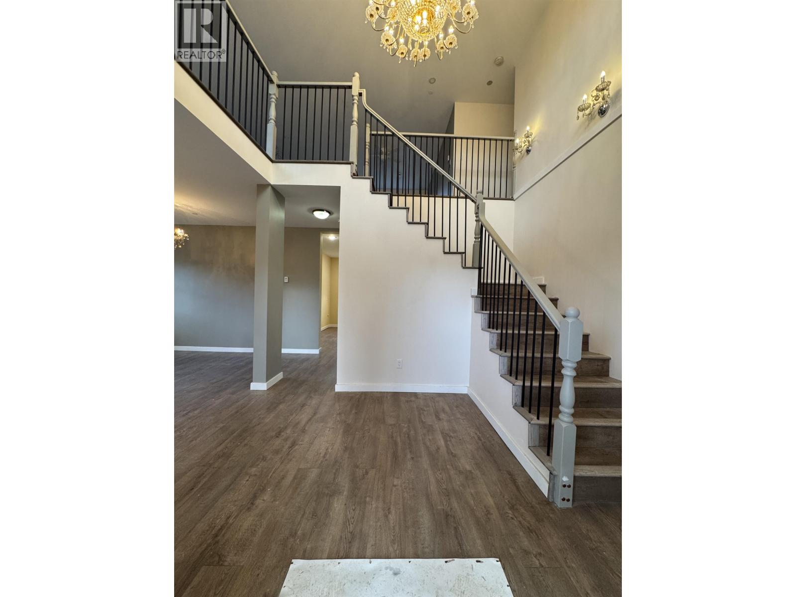 A chandelier hangs over a staircase in a home.