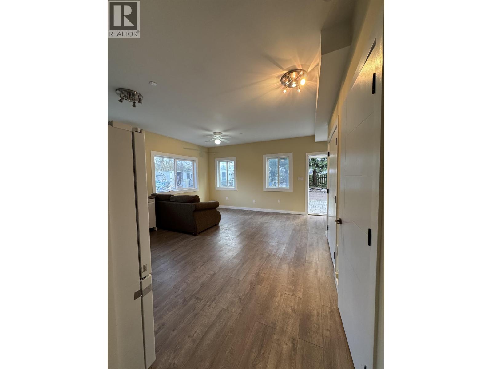 A spacious living room with hardwood floors and a large window.