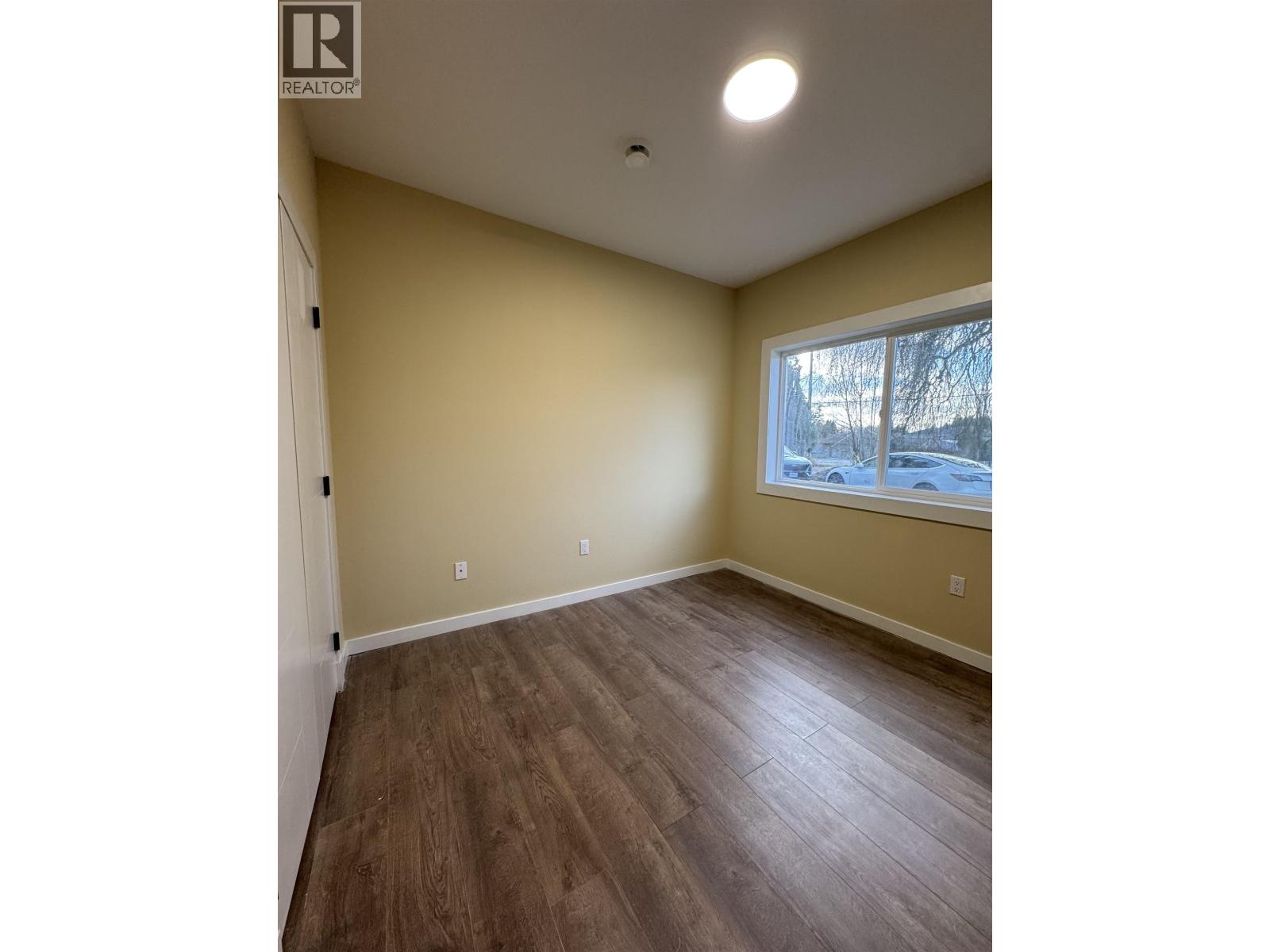 A room with wooden flooring and a window.