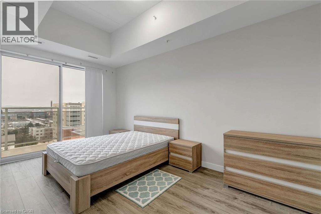 A bedroom with a large bed and a balcony overlooking a cityscape.