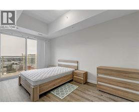 A bedroom with a large bed and a balcony overlooking a cityscape.