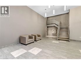 A spacious room with a staircase, two chairs, and a table.