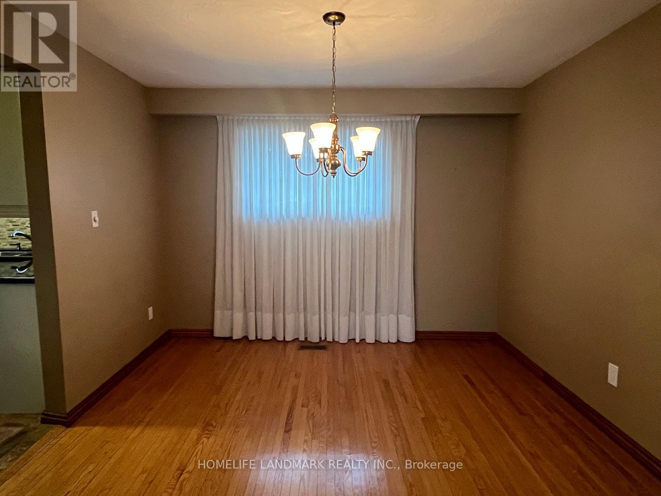 A room with wooden floors and a chandelier.