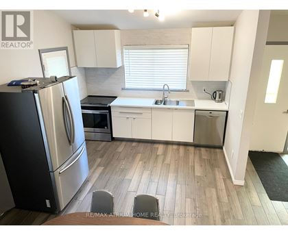 A kitchen with white cabinets and a black refrigerator.